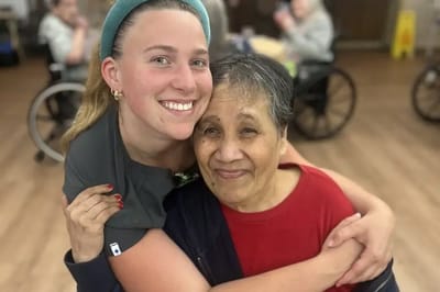 Resident and staff member sharing a warm embrace