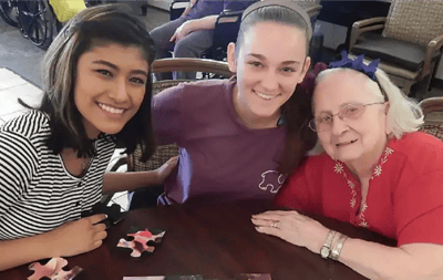 Residents engaged in a puzzle activity with volunteers