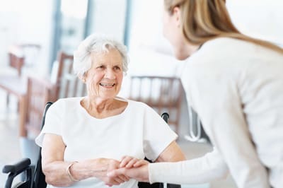 Senior resident smiling and interacting with staff member