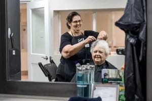 Wesley Manor Health Center, Nursing Home in Frankfort, IN — Hair stylist assisting elderly woman in salon setting