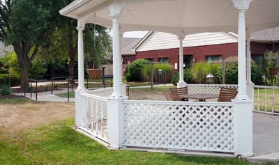 Outdoor gazebo with seating in a landscaped area