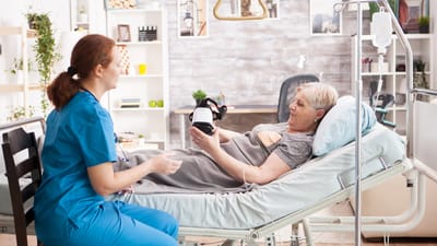 Healthcare staff assists a resident in a cozy room