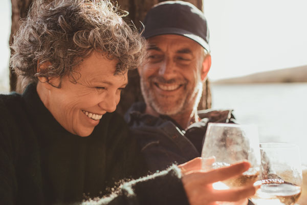 Two residents enjoying drinks by the water