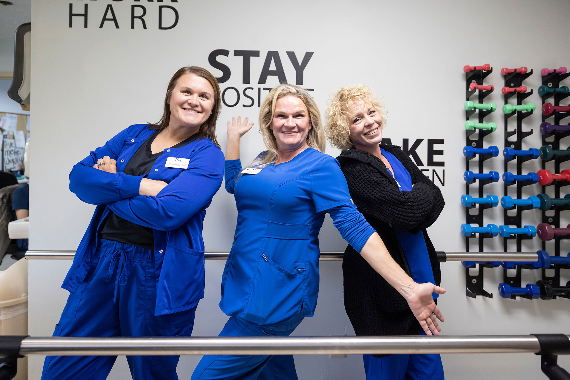 Three staff members posing in an activity room