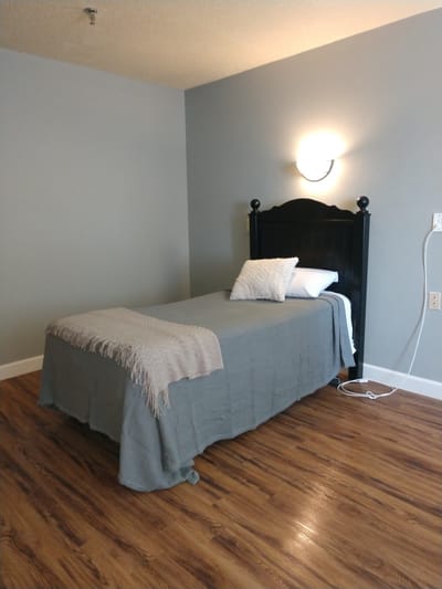 Simple bedroom setup with a bed and accent blanket