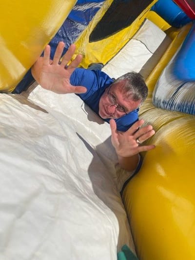 A man sliding down an inflatable slide
