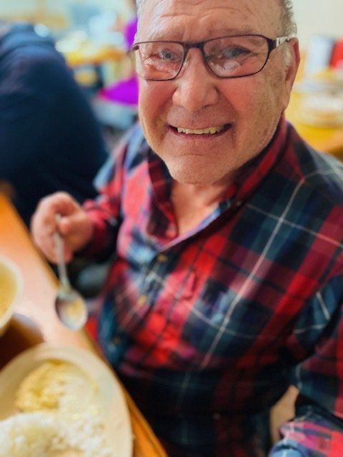 A smiling resident enjoying a meal at the facility