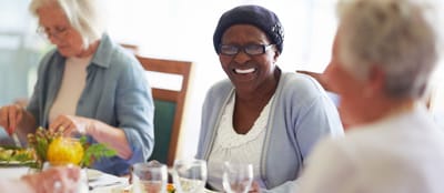 Seniors enjoying a meal together in a dining room.