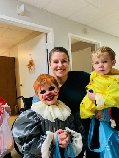 Staff member and children in costumes during an event