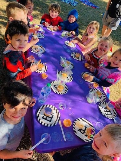 Children enjoying snacks at an outdoor table