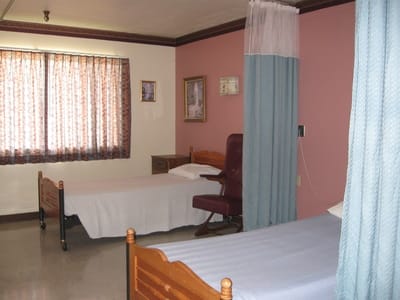 A simple bedroom with two beds and curtains