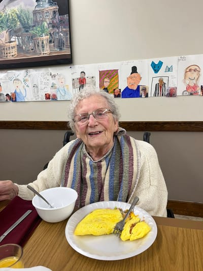 A resident enjoying an omelet in a dining area