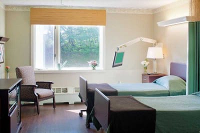 A shared resident room with two beds and natural light