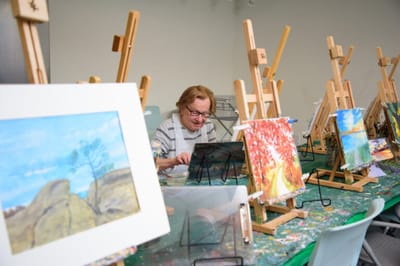 Resident painting in an art activity room