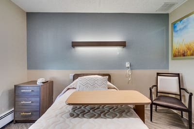 A private resident room with a bed and chair