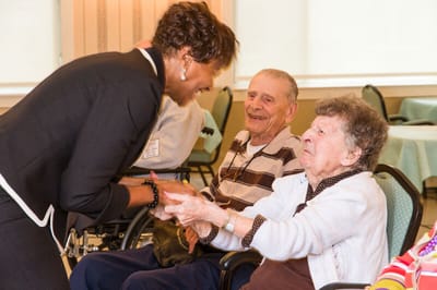 Staff interacting warmly with residents in a common area
