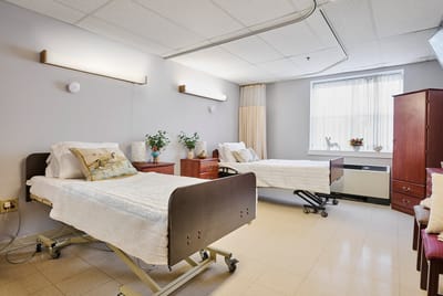 A private resident room with two beds and decor