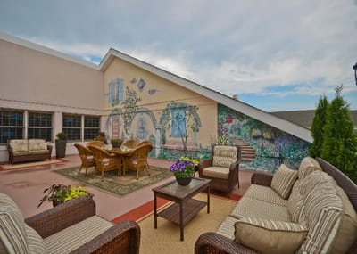 Outdoor seating area with a mural and plants