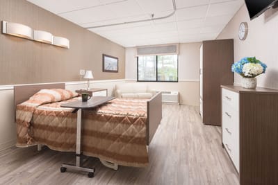 Well-furnished resident room with a bed and seating area