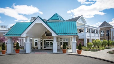 Exterior view of a senior living facility with landscaped gardens