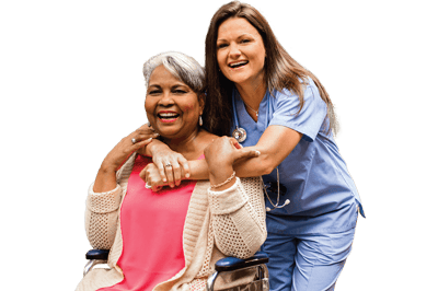 A caregiver embracing a smiling resident in a wheelchair