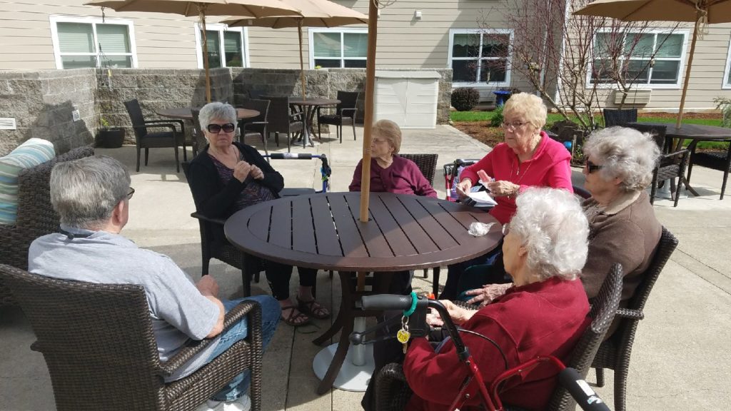 Residents enjoying a sunny day outdoors at a table