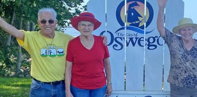 Residents celebrating outdoors by facility signage