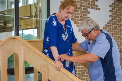 Staff assisting a resident on the stairs