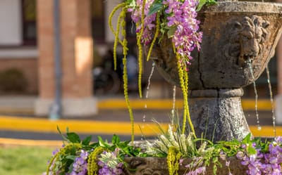 A decorative outdoor fountain adorned with flowers