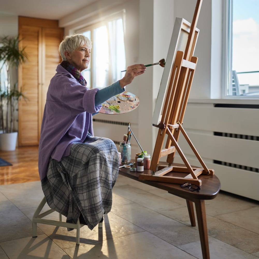Senior resident painting in a bright indoor space