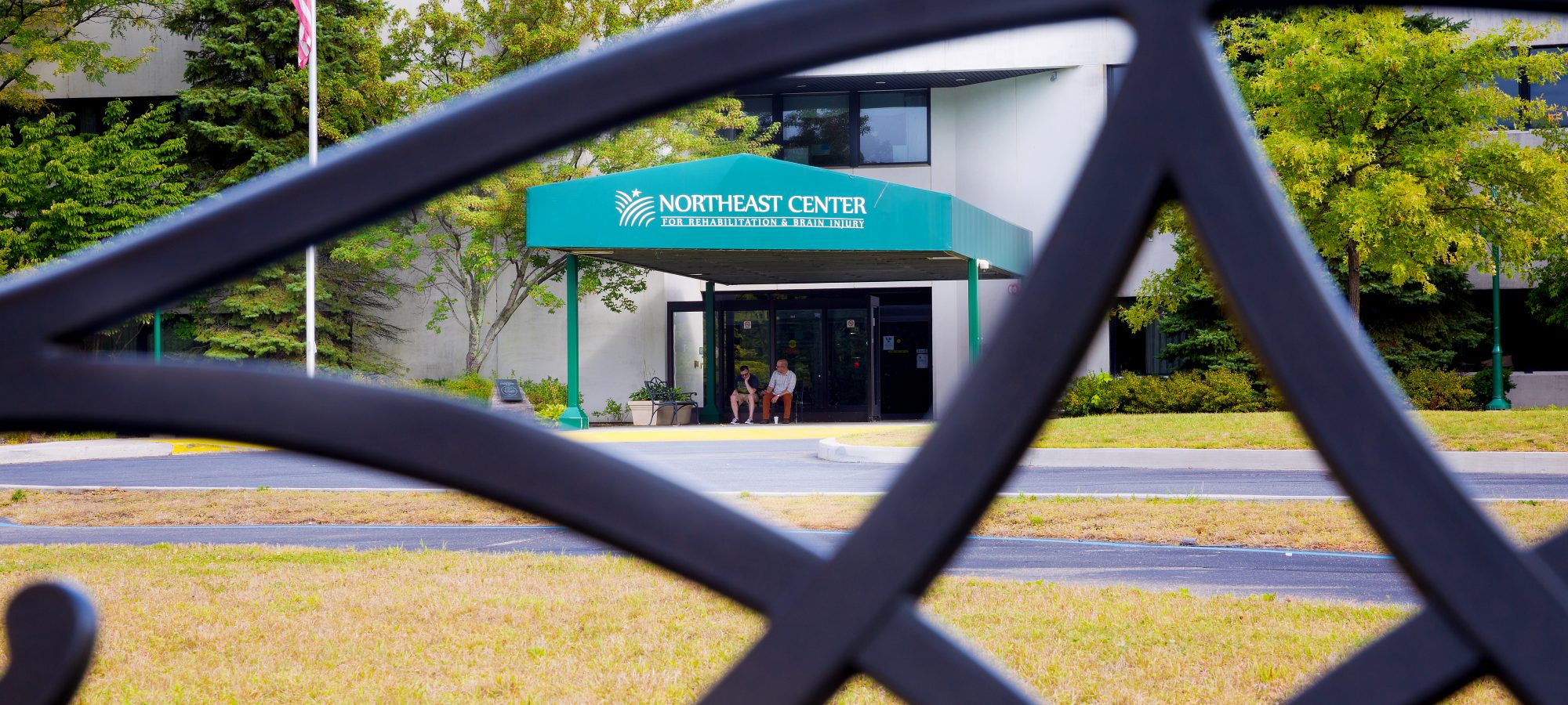 Entrance of Northeast Center with residents sitting outside