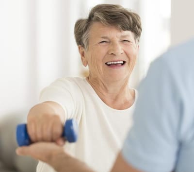 Senior woman exercising with a dumbbell in an activity room