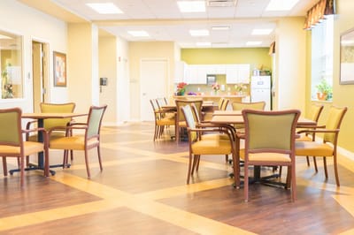 Bright common area with dining tables and chairs.