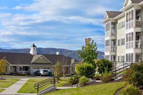 Exterior view of a senior living facility with gardens