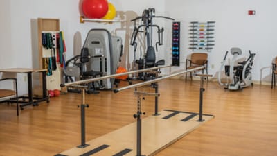 Physical therapy room with equipment and exercise bars