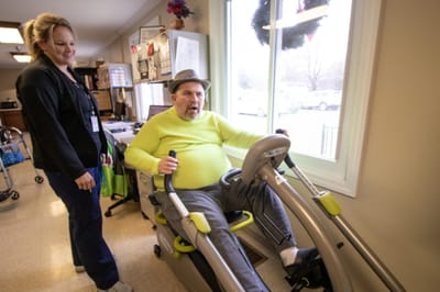 Resident engaging in exercise with staff assistance