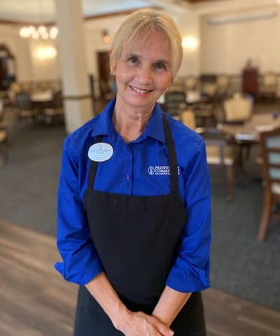 Staff member smiling in the facility's dining area