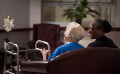 Two women talking in a cozy common area