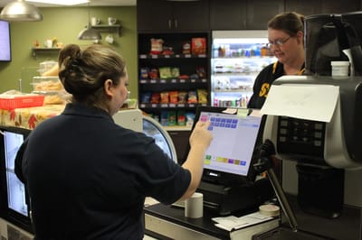 Staff member assisting a resident at the cafe