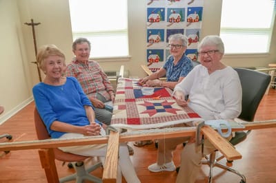Four residents engaging in a quilting activity