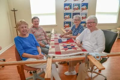 Residents quilting together in a bright room