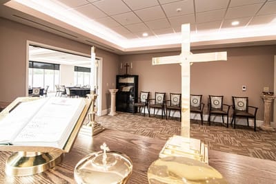 Interior view of a chapel with golden cross and seating