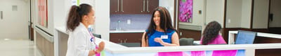 Staff member at reception desk engaging with a visitor