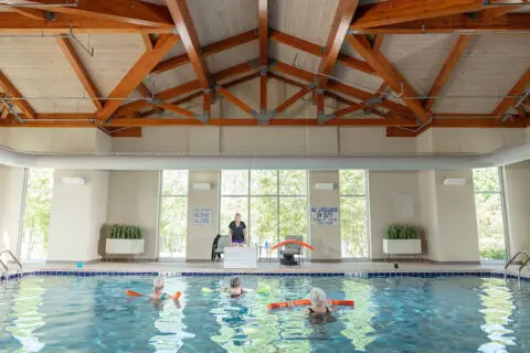 Residents participating in a water exercise class in a pool