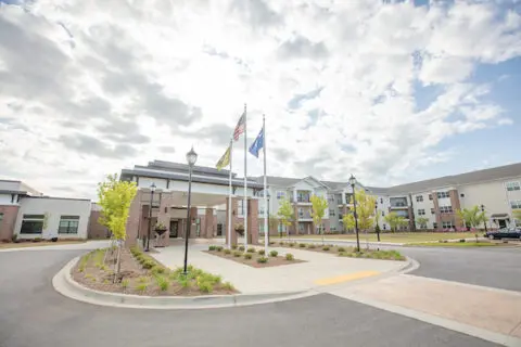 Exterior view of a senior living facility with flags