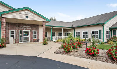 Exterior view of a senior living facility entrance with flowers