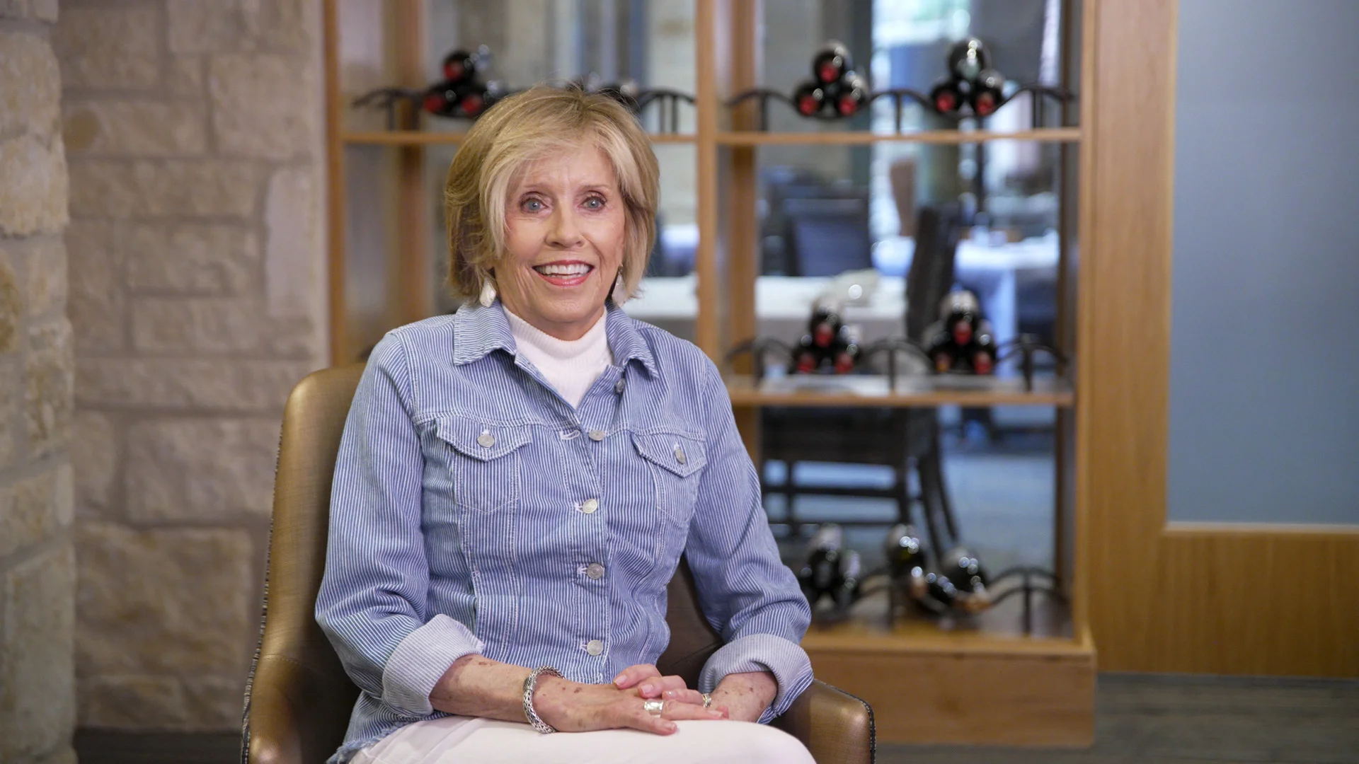 A senior woman smiling in a cozy interior setting