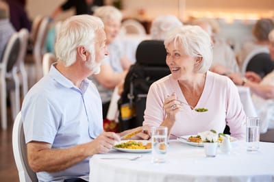 Two residents enjoying a meal together in the dining room