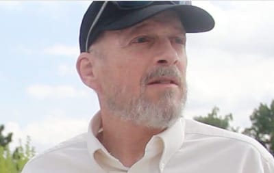 A man with a beard wearing a cap outdoors