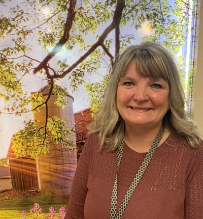 Grandview Care Center Inc., nursing home in Athens, GA — Smiling woman in front of a nature-themed backdrop